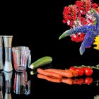 Still life composition with books, ornate cylinders, vase, lilies, and tulips on dark