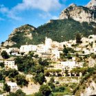 Colorful Hillside Village with Greenery and Blue Sky