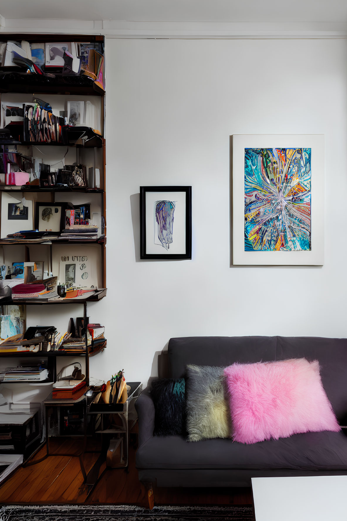 Inviting living space with gray sofa, colorful cushions, bookshelf, and vibrant artwork