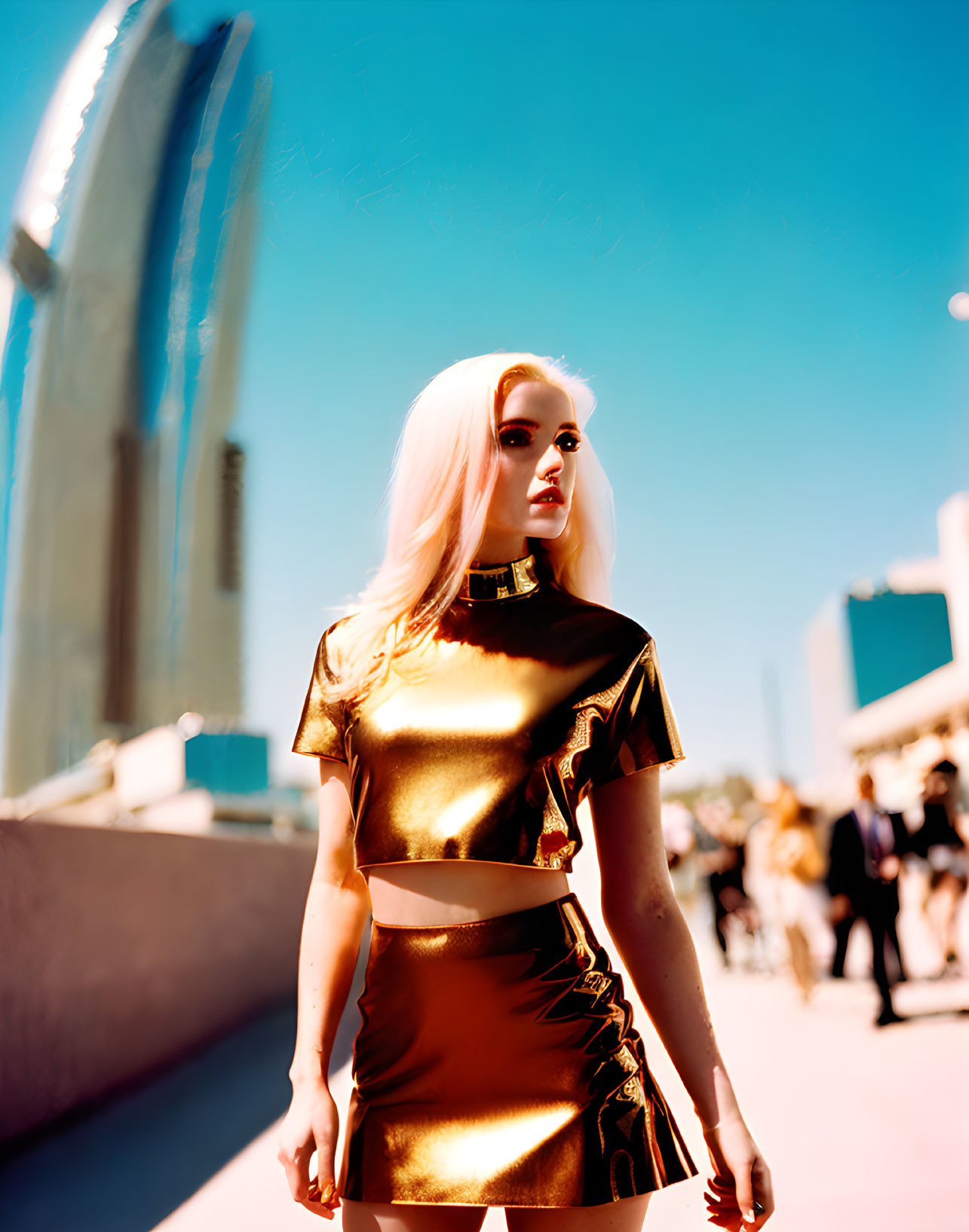 Blonde woman in golden outfit on sunny street