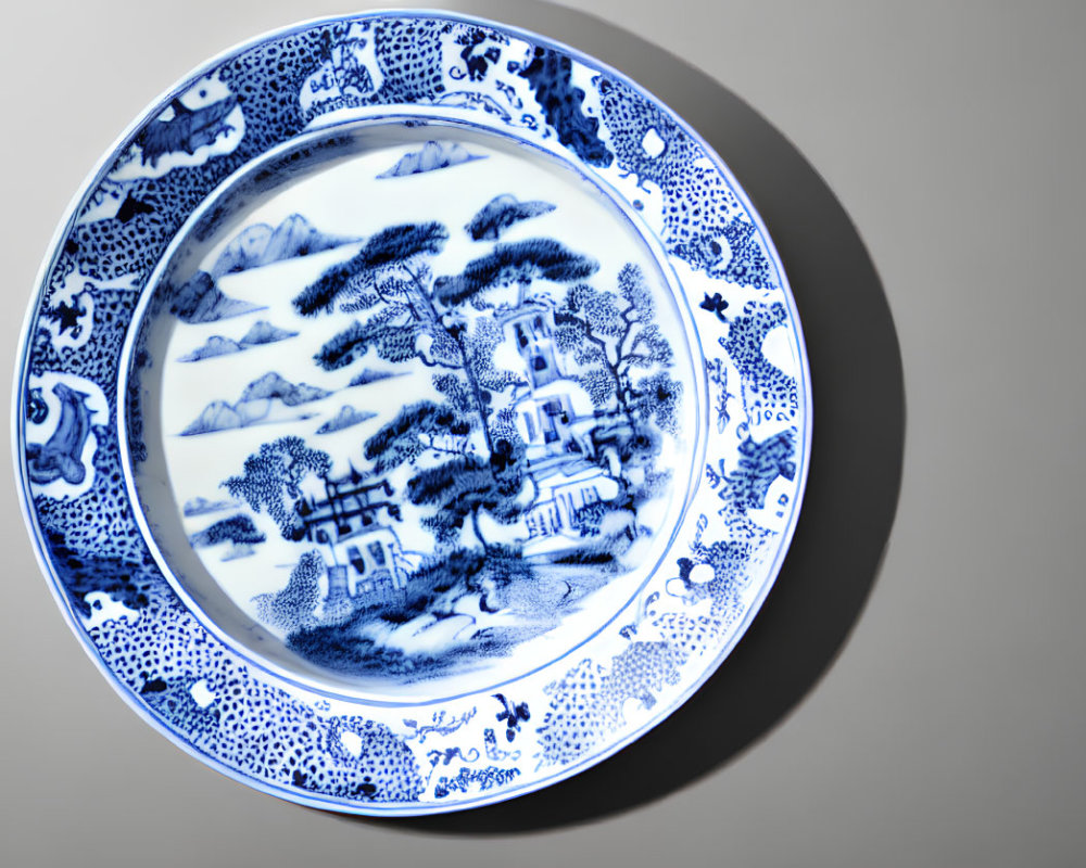 Blue and White Porcelain Plate with Landscape Design on Grey Background