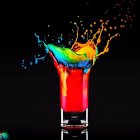 Colorful neon liquids collide, creating dynamic explosion.