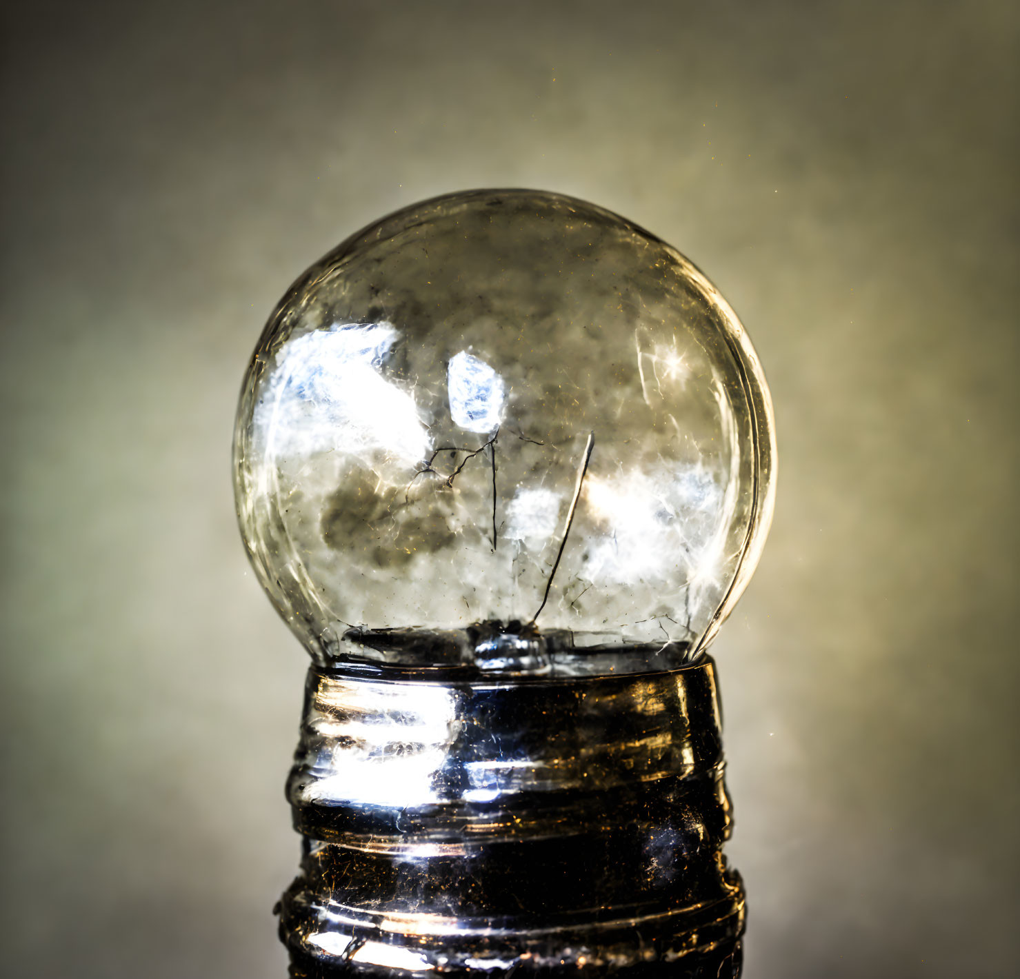 Classic incandescent light bulb with visible filament and reflective base.
