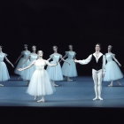 Male lead surrounded by female ballet dancers in white tutus on stage