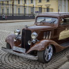 Classic Cars Parked on Cobblestone Street in Old Town Setting