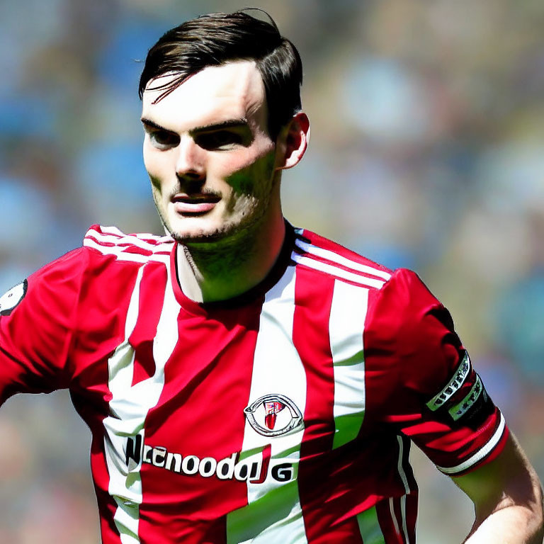 Short-haired person in red and white soccer jersey at stadium.