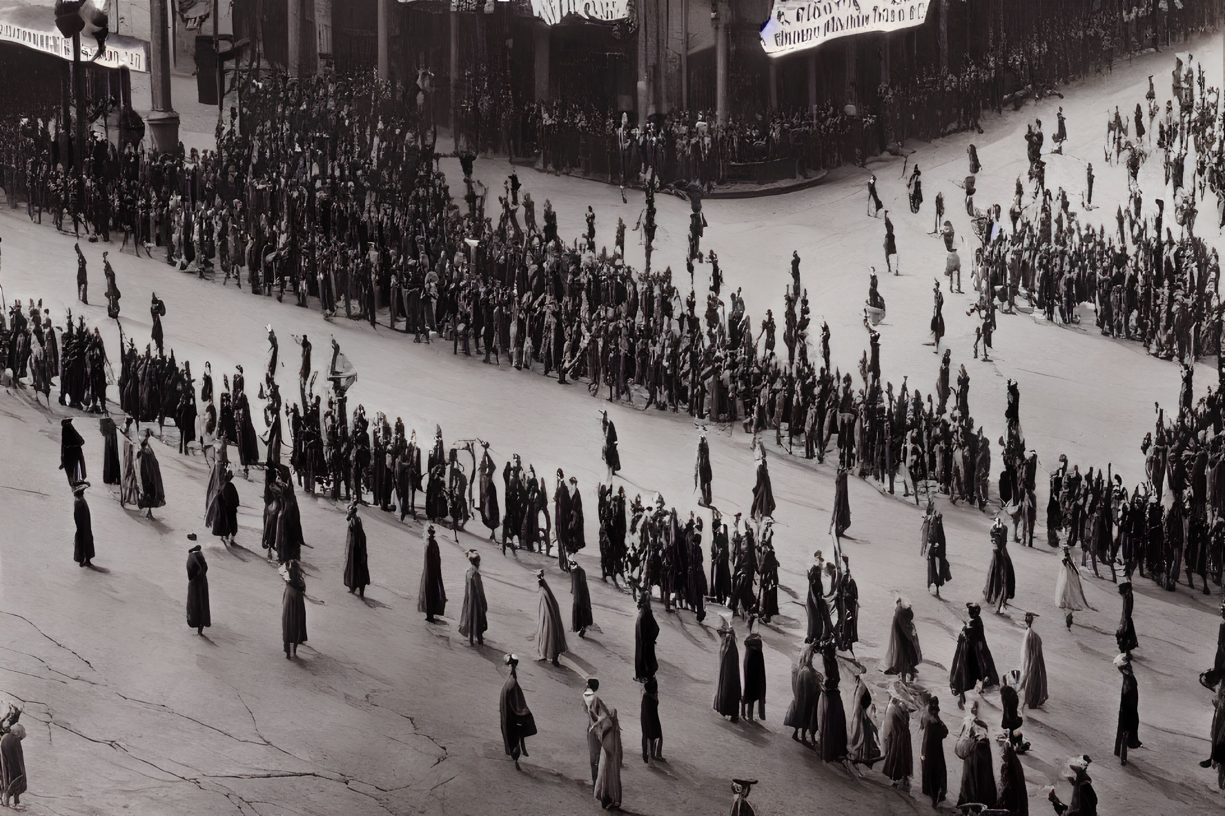 Monochrome image of crowd in traditional attire marching on street