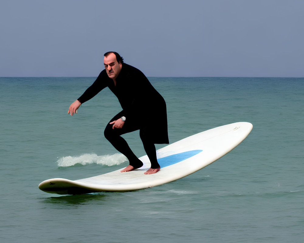 Surfer in black wetsuit on calm ocean under clear blue sky