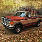 Rusty orange pickup truck with cowboy, horse, and passengers