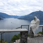 Person in White Cloak Stands by Foggy Lakeside