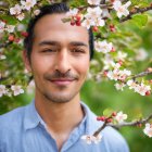 Bearded man smiling in garden with blue shirt