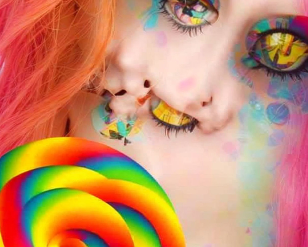 Vibrant rainbow makeup and pink hair with swirled lollipop