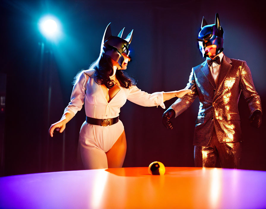 Two stylish individuals in Batman masks with golden apple on table