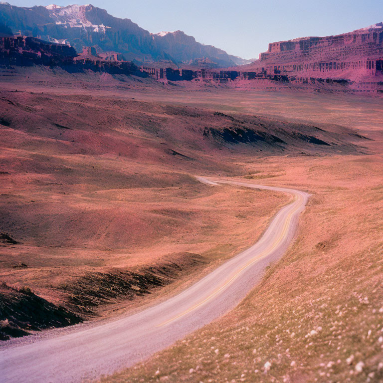 Curving Road in Barren Landscape with Rugged Cliffs