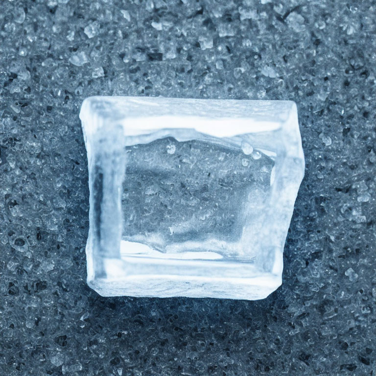 Translucent ice cube with air bubbles on rough surface