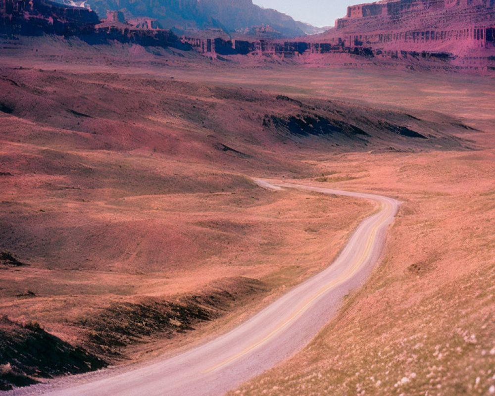 Curving Road in Barren Landscape with Rugged Cliffs