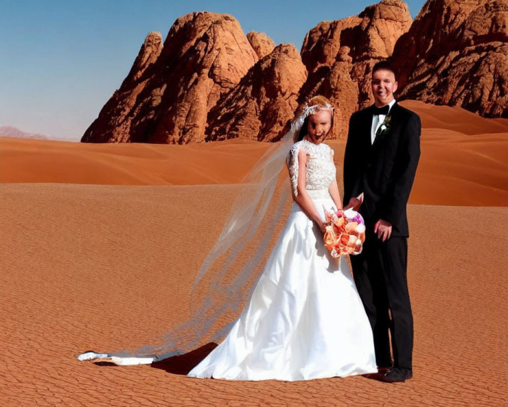 Newlyweds smiling in desert with red sand dunes & rocky backdrop