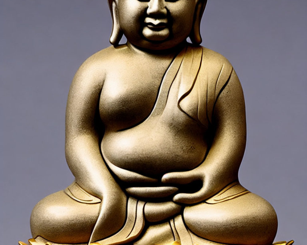 Golden Buddha Statue in Meditative Pose on Lotus Flower Base Against Grey Background