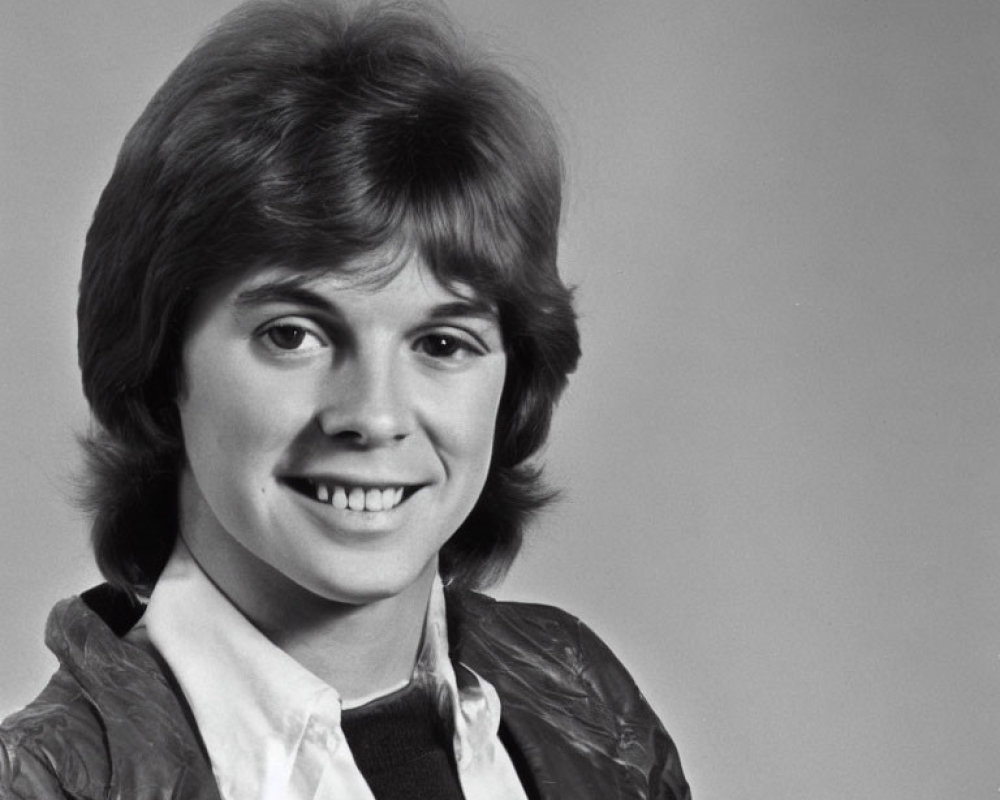 Monochrome image of smiling woman in short hair and light jacket