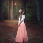 Dark room with girl in pink dress, surrounded by serpentine creatures and desolate bed.