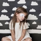 Blonde Girl in White Dress on Rocky Outcrop with Cloudy Sky