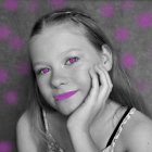 Young girl with long hair and hand on cheek in vibrant pink flower setting