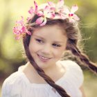 Portrait of woman with pink flowers in hair in mystical forest setting