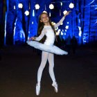 Ballerina in Blue Costume with Peacock Pattern Performing under Glowing Starry Lights