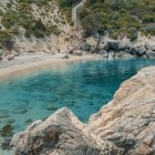 Tranquil mountain lake with coniferous trees and patterned stones