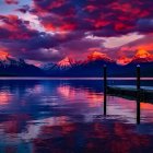 Snow-capped mountains reflected in serene lake at sunrise or sunset