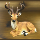 Realistic deer model with antlers on wooden wall and tall grass