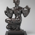 Monochrome sculpted angel with detailed wings and draped clothing seated on a pedestal