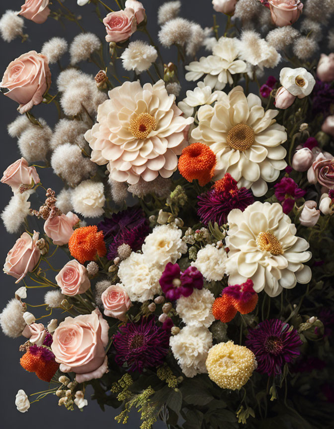 Colorful floral bouquet on dark background featuring pink roses, dahlias, orange blooms, and white botanical