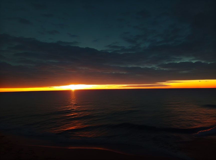 Tranquil Beach Sunset with Vibrant Orange Glow