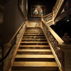 Split wooden staircase with painting at landing