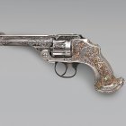 Engraved wooden handle revolver with golden accents on gray background