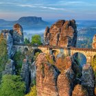 Majestic stone bridge over autumn canyon under blue sky