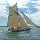 Sailboat with taut sails navigating choppy seas under stormy sky