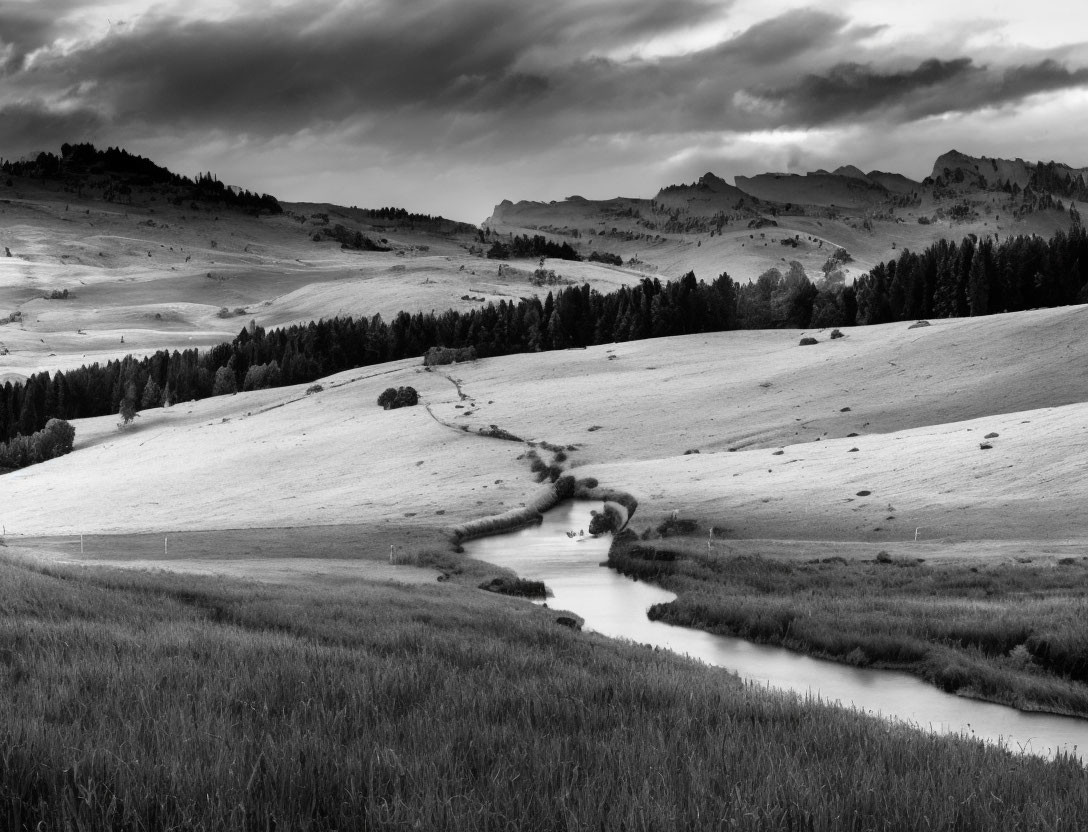 Tranquil black and white landscape with winding river and rolling hills