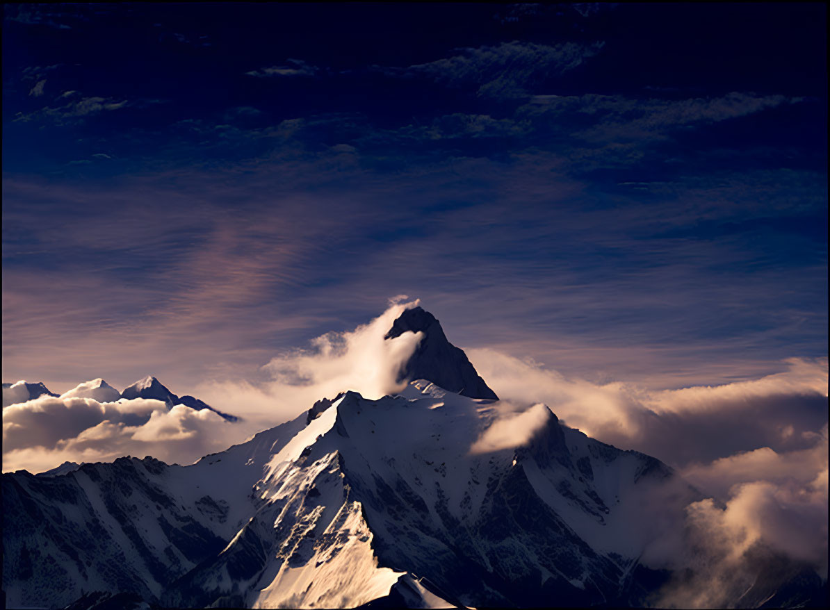 Snow-capped mountain peak in twilight sky with clouds