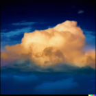 Dramatic cumulus cloud in golden sunlight against stormy twilight sky