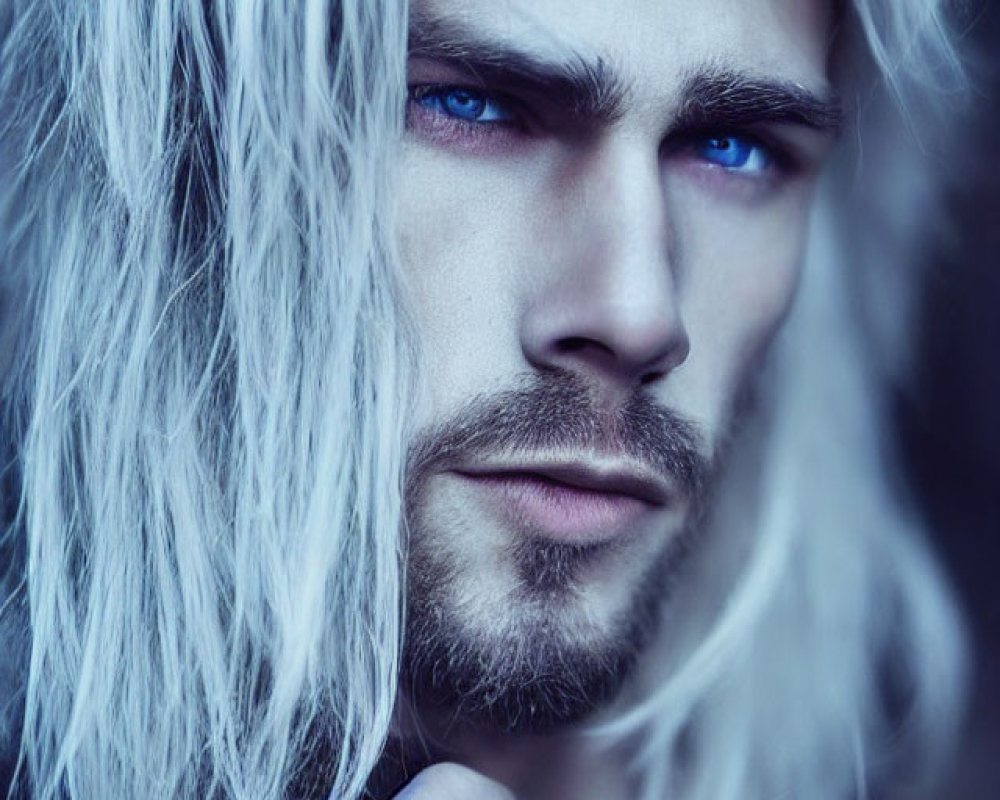 Portrait of person with striking blue eyes and long wavy white hair gazing at camera.