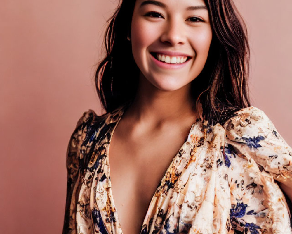 Smiling woman in floral dress on pink background