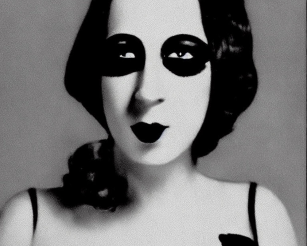 Monochrome photo of woman with painted mask-like eyes and vintage style