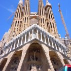 Intricate facade of Sagrada Familia with spires and sculptures under clear blue sky