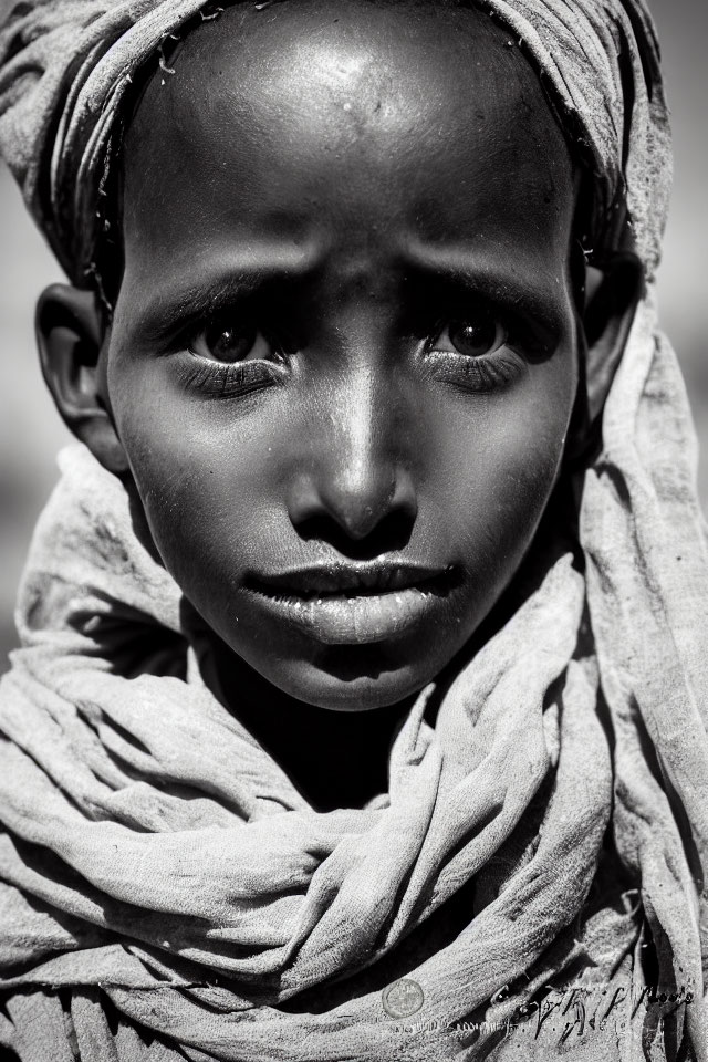 Monochrome portrait of young person in headscarf with expressive eyes