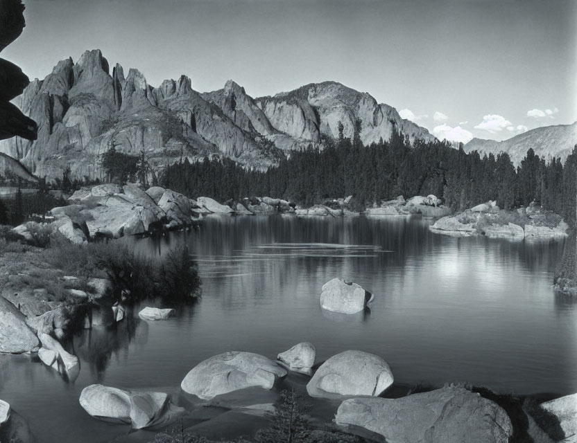 Monochrome landscape with lake, boulders & mountains