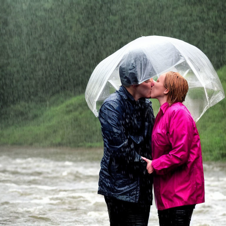 Couple kissing under transparent umbrella in rain