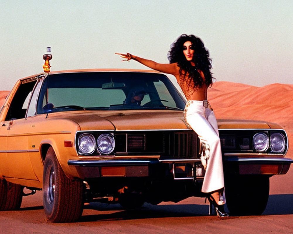 Dark-haired person poses stylishly next to yellow car in desert setting