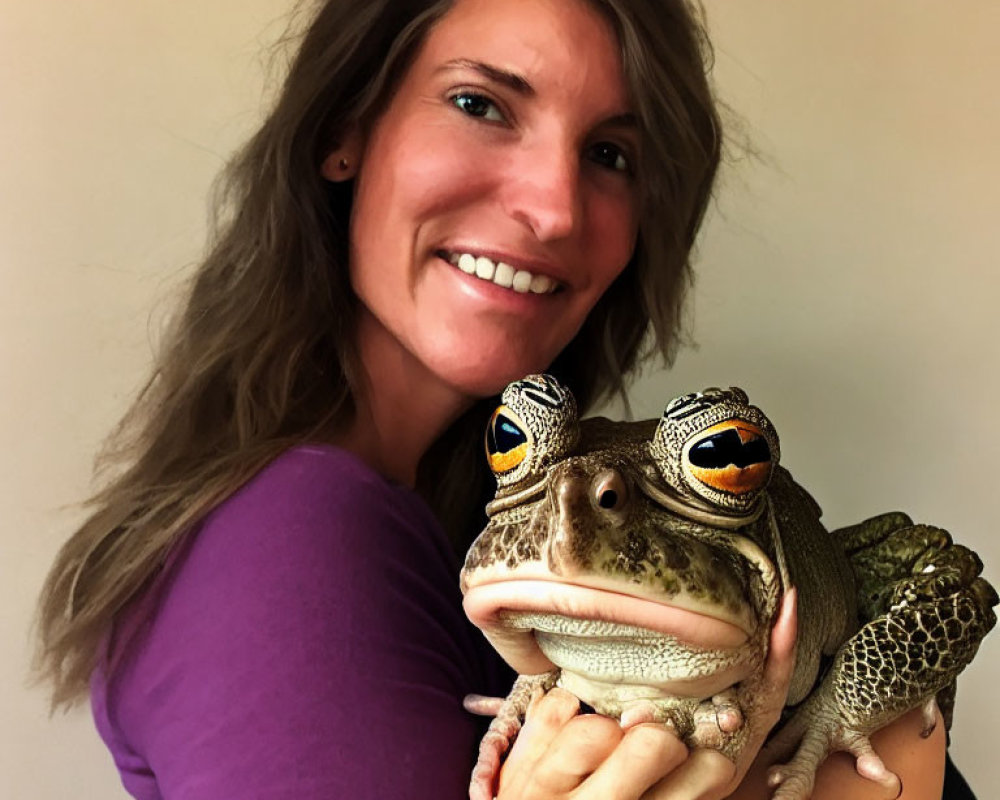 Smiling woman with large frog in purple top